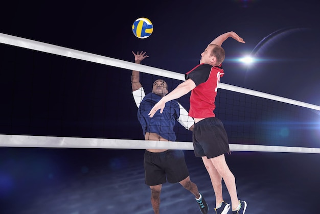 Composite image of sportsman hitting volleyball