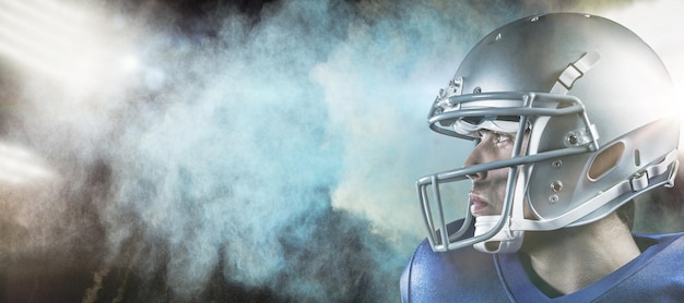 Composite image of sportsman with helmet looking away