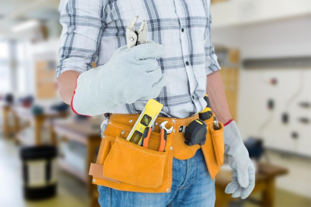 Photo composite image of technician with tool belt around waist holding pliers