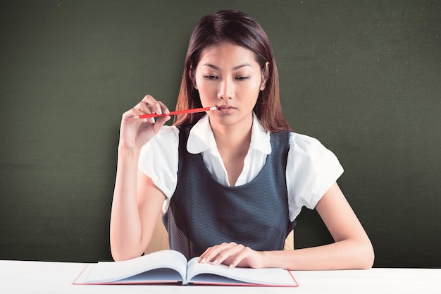 Composite image of thoughtful businesswoman reading