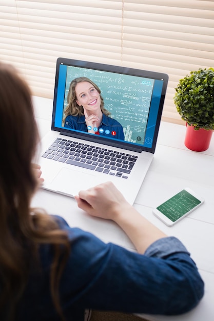 Composite image of thoughtful teacher smiling in front of blackboard