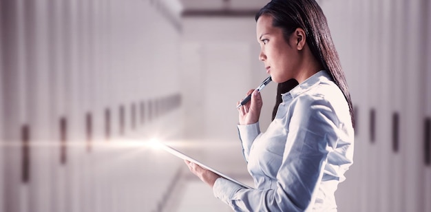 Composite image of thoughtful woman with pen on cheek holding notepad