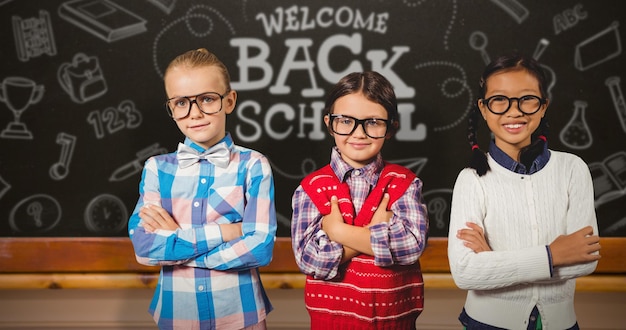 Composite image of three school kids with arms crossed