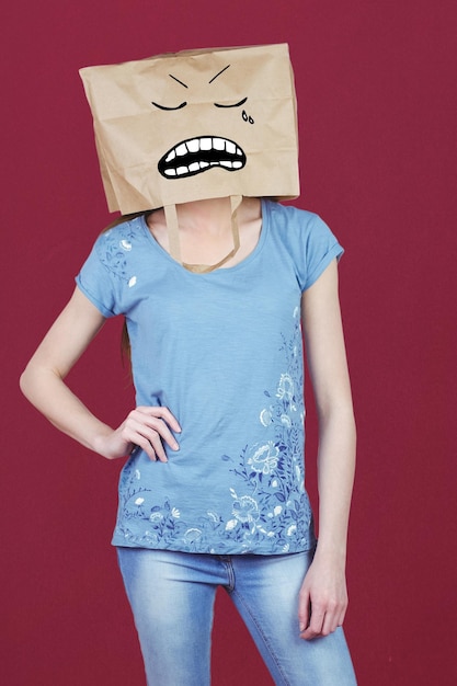 Composite image of woman posing with bag on head