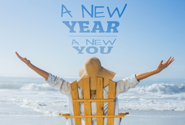 Composite image of woman relaxing in deck chair by the sea