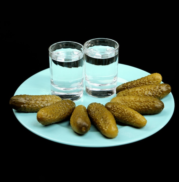 Compositie met glas wodka en snacks op kleurplaat geïsoleerd op zwart