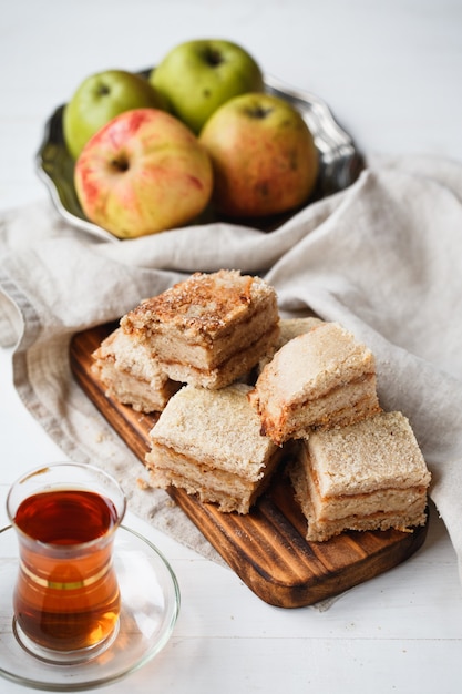 Composition of apple pie on a wooden board in beige tones