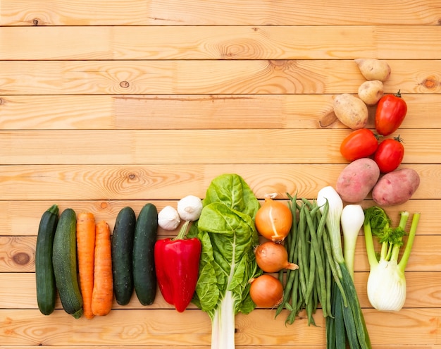 Composition of assorted raw organic vegetables on a wooden table. Vegan, vegetarian detox diet