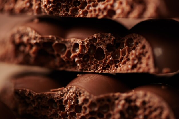 Composition of bars and pieces of milk porous chocolate close-up