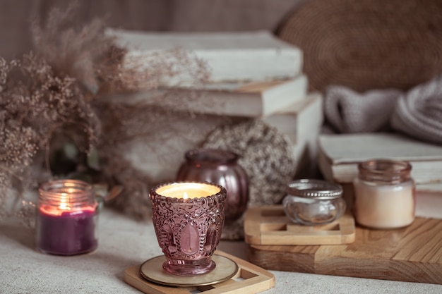 Composition of beautiful vintage candlesticks with burning candles on a blurred background.