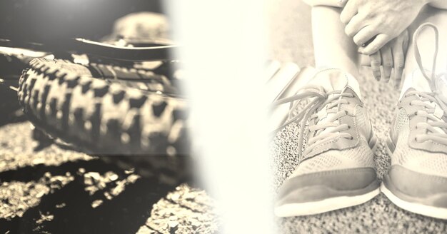 Composition of bicycle wheel on road with overexposure and person putting on shoes on in sepia tone