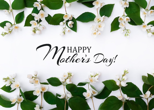 Composition of blooming flowers. Line of jasmine with green leaves at the top and at the bottom. Inscription Happy Mother's Day. Summer concept for Mother's Day. Top view, close up, copy space