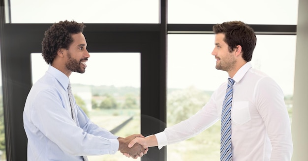 Photo composition of businessmen shaking hands in office