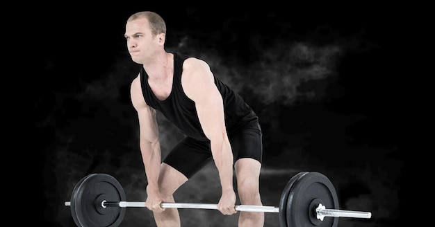 Composition of caucasian male weightlifter with barbell with smoke on black background