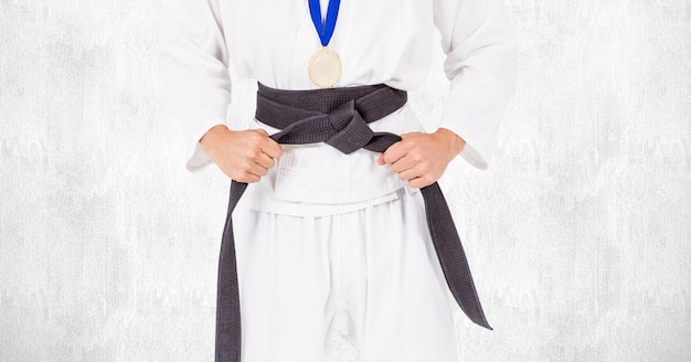 Composition of caucasian martial artist with black belt and gold medal on white background