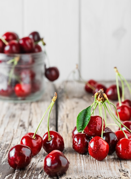 Composition of cherries on a light wooden table