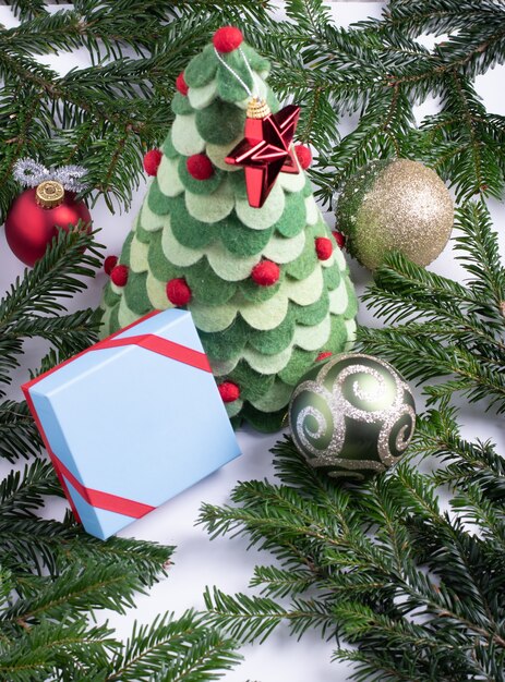 Composition of Christmas toy tree surrounded with real fir branches and christmas decorations