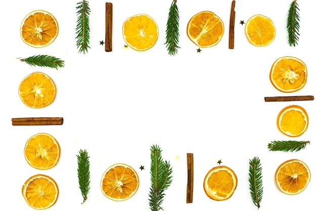 Composition of cinnamon, fur tree and dried oranges on white background