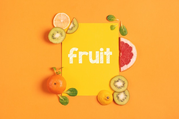 composition of citrus fruit, orange, lemon and kiwi on yellow background