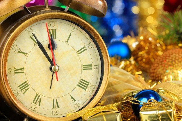 Composition of clock and christmas decorations on bright background