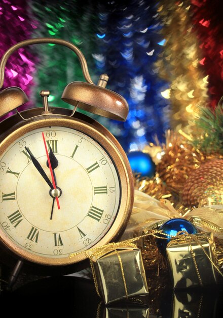 Composition of clock and christmas decorations on bright background