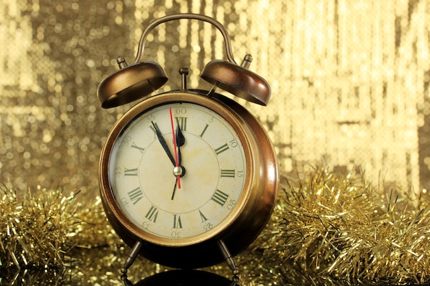 Photo composition of clock and christmas decorations on bright surface