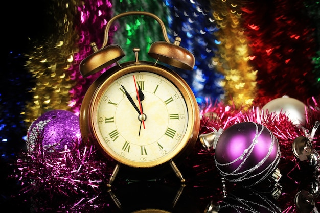 Composition of clock and christmas decorations on bright surface