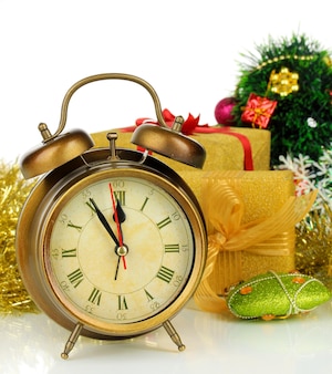 Composizione dell'orologio e delle decorazioni natalizie isolate su bianco