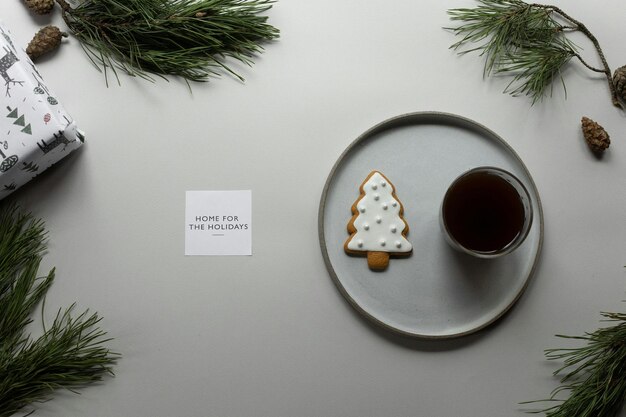 Composition of coffee and cookie on table with greeting card and coniferous branches Stock Photo