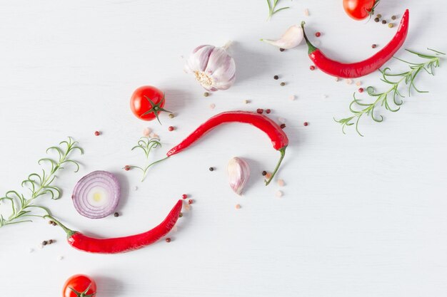 Composizione di semi di pepe colorati peperoncino fresco pomodori aglio cipolla blu e rosmarino erba