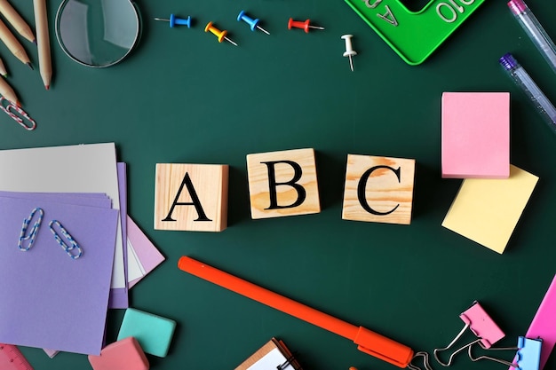 Photo composition of colourful stationery and word abc on chalkboard