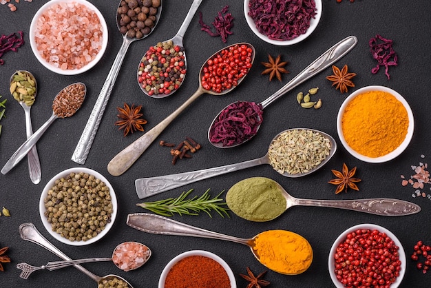 Composition consisting of variations of spices in white bowls and metal spoons