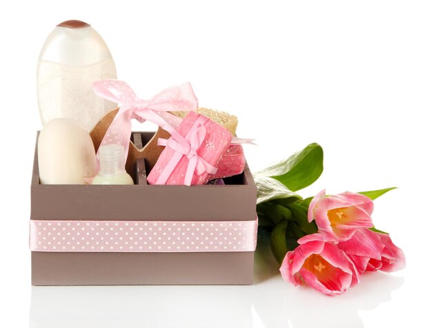 Composition of cosmetic bottles and soap in crate isolated on white