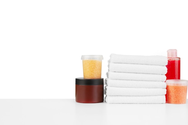 Composition of cosmetic bottles and towels isolated on white