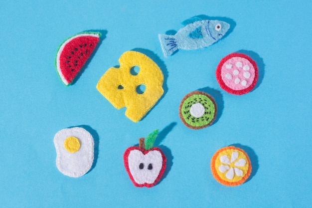 The composition of crafts made of felt  in the form of food and fruits. Hobbies and colorful crafts. View from above.