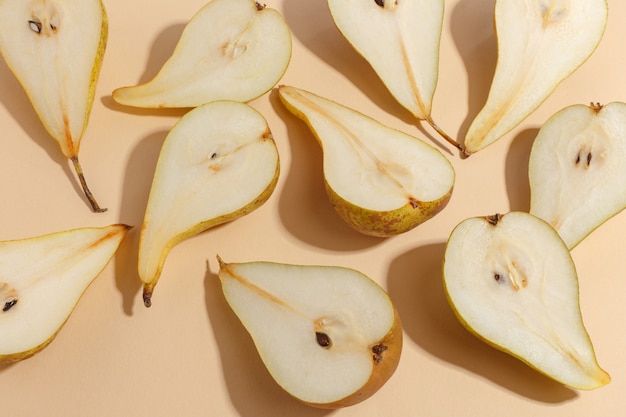 Composition of cut pears on a beige. Top view.