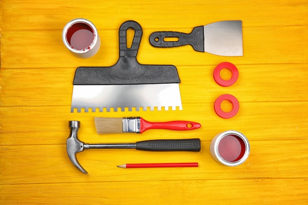 Composition of decorator and house renovation tools on wooden table