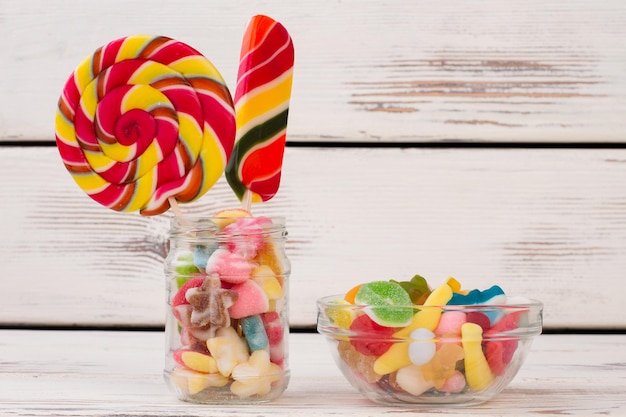 Composition of delicious candies on wooden background.