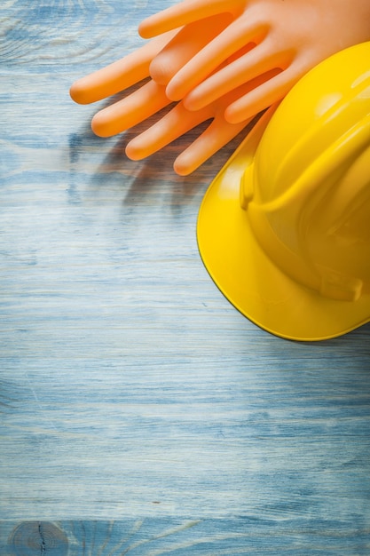 Foto composizione di guanti dielettrici che costruiscono casco su tavola di legno concetto di elettricità