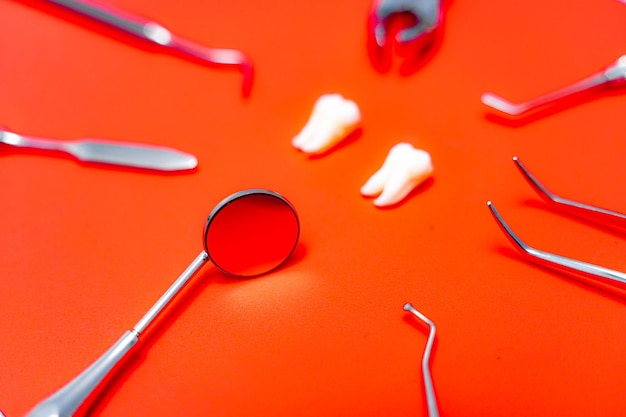 Composition of different dentist equipment Doctors tools on orange background