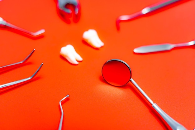 Composition of different dentist equipment. Doctors tools on orange background.