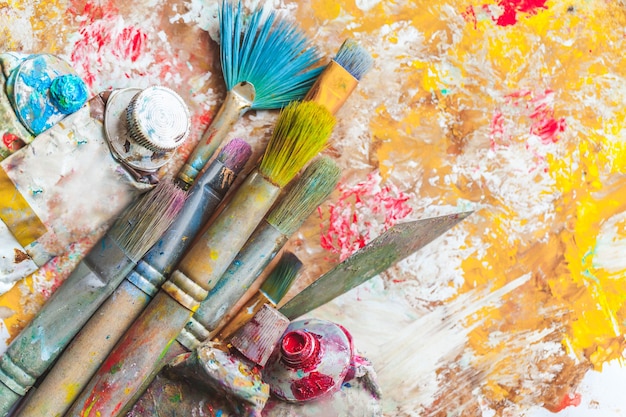 Composition of dirty painting brushes on colorful background