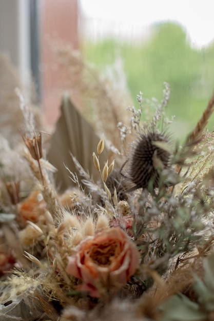 Composition of dried flowers in a box with palm leaf rose eucalyptus pampas grass lotus in a rou