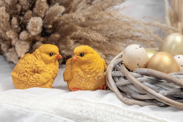 Composition of eggs in a nest and chickens on a light background