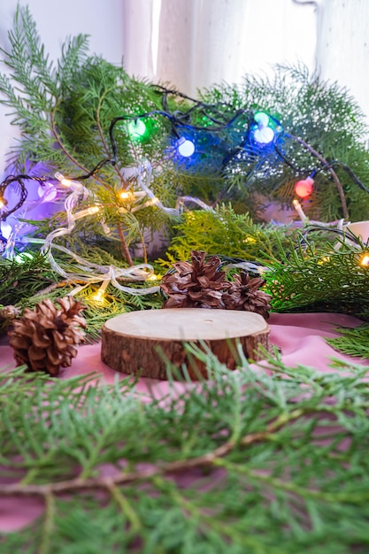 The composition features Christmas and New Year's products. old round wood with spruce leaf decoration. product display ideas