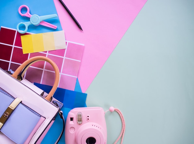 Photo composition of female graphic designer elements: color scheme, photo camera, scissors and colored paper with copyspace background