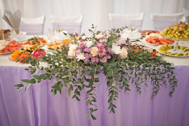 お祝いのテーブルの中心的な装飾としての花の構成