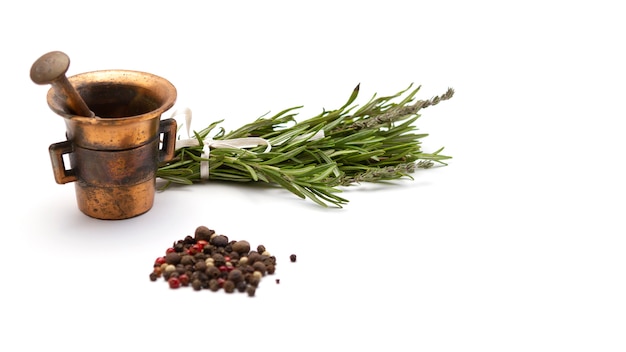 Composition of fragrant herbs-rosemary and thyme, black, pink and white pepper, copper mortar for seasonings, close-up