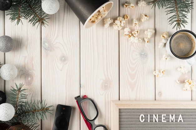Composition frame scattered popcorn 3d glasses fir tree ball festive garland and remote control on wooden background