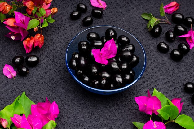 Composition of fresh black plum with flowers